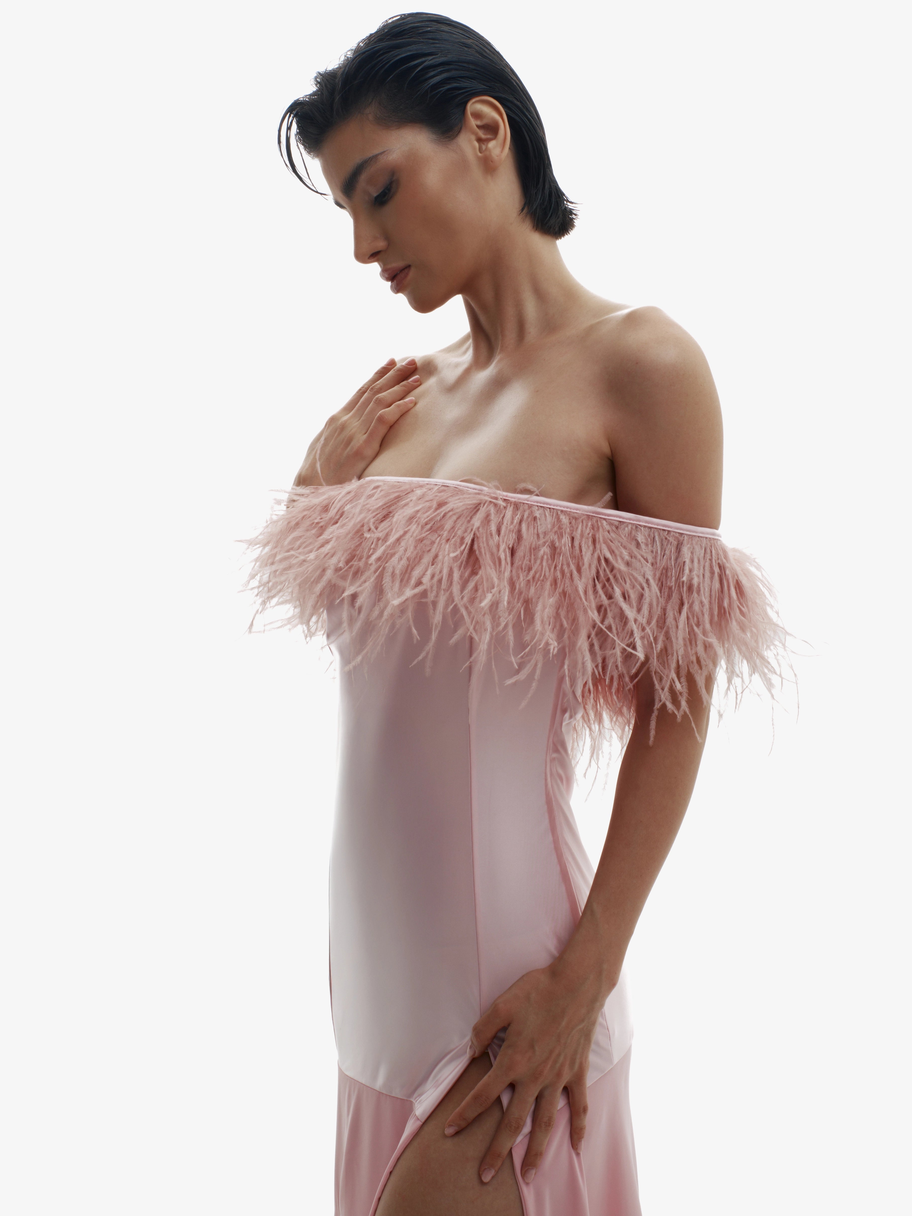 Woman wearing a pink feathered dress on a white background
