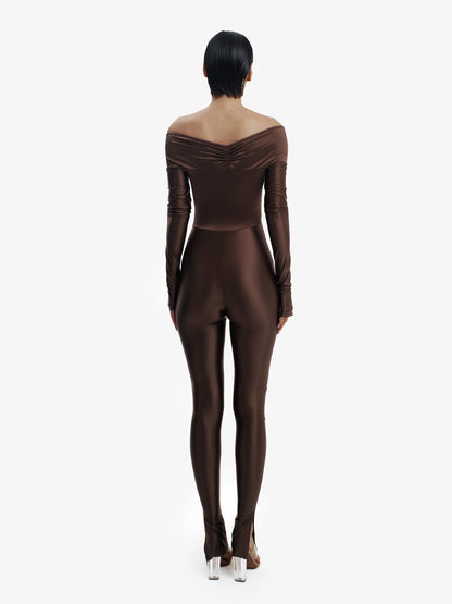 Brown statement jumpsuit, unapologetic style, confident luxury fashion.