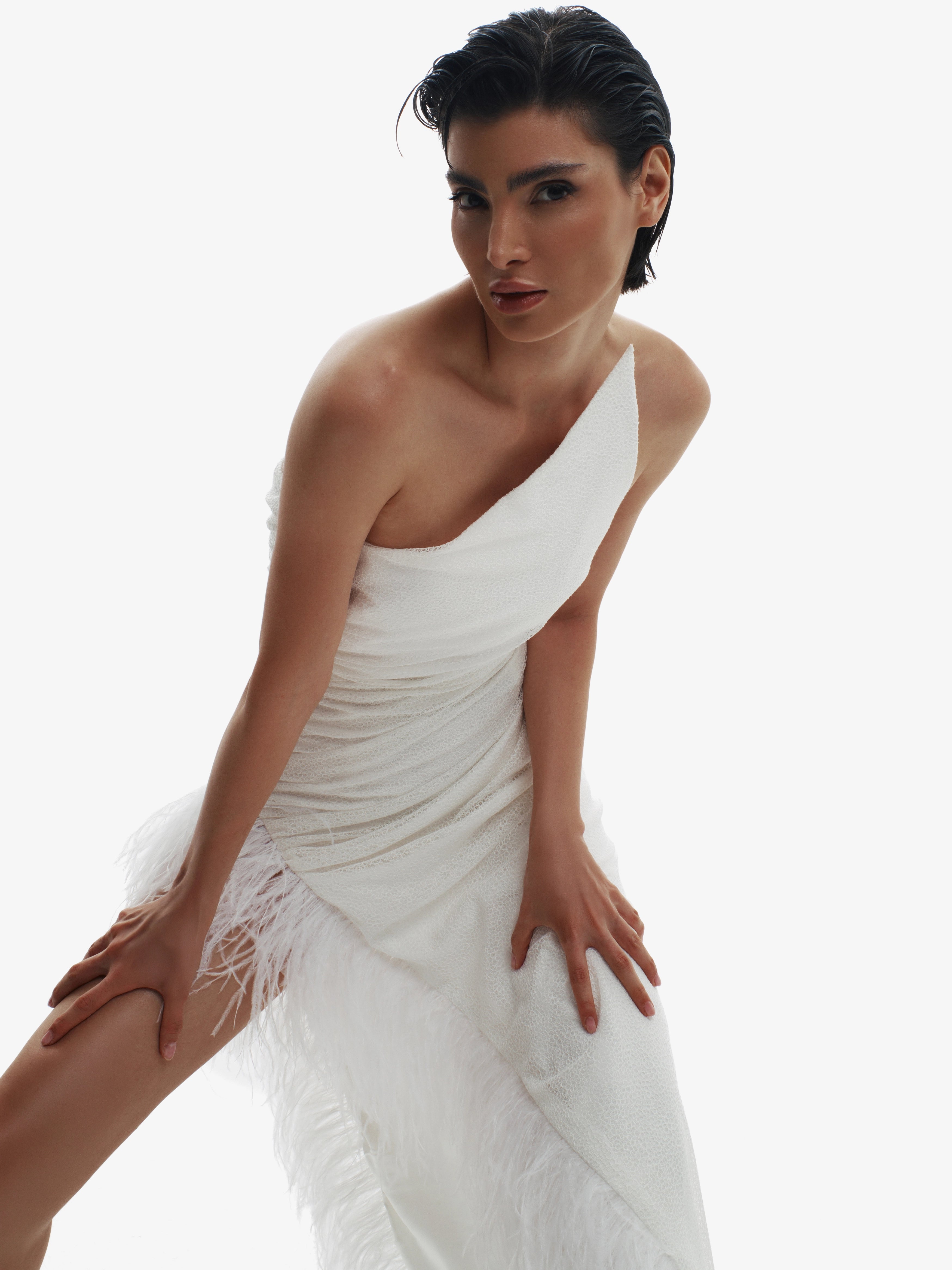 Woman wearing a white one-shoulder dress on a white background